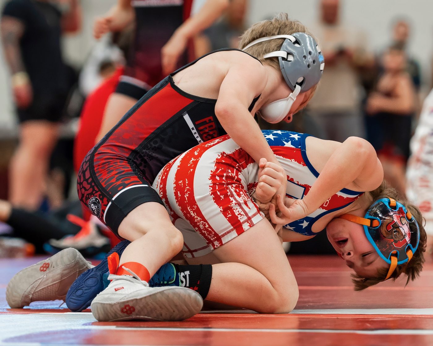 Young Frog Empire wrestler in singlet competing at a tournament