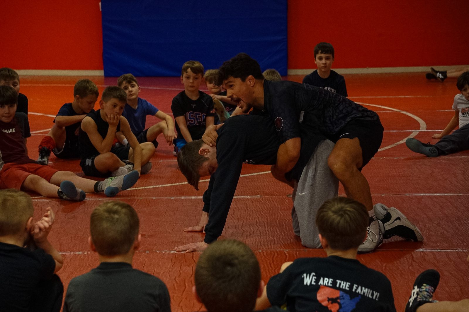 Julian Ramirez demonstrating a wrestling technique to young athletes